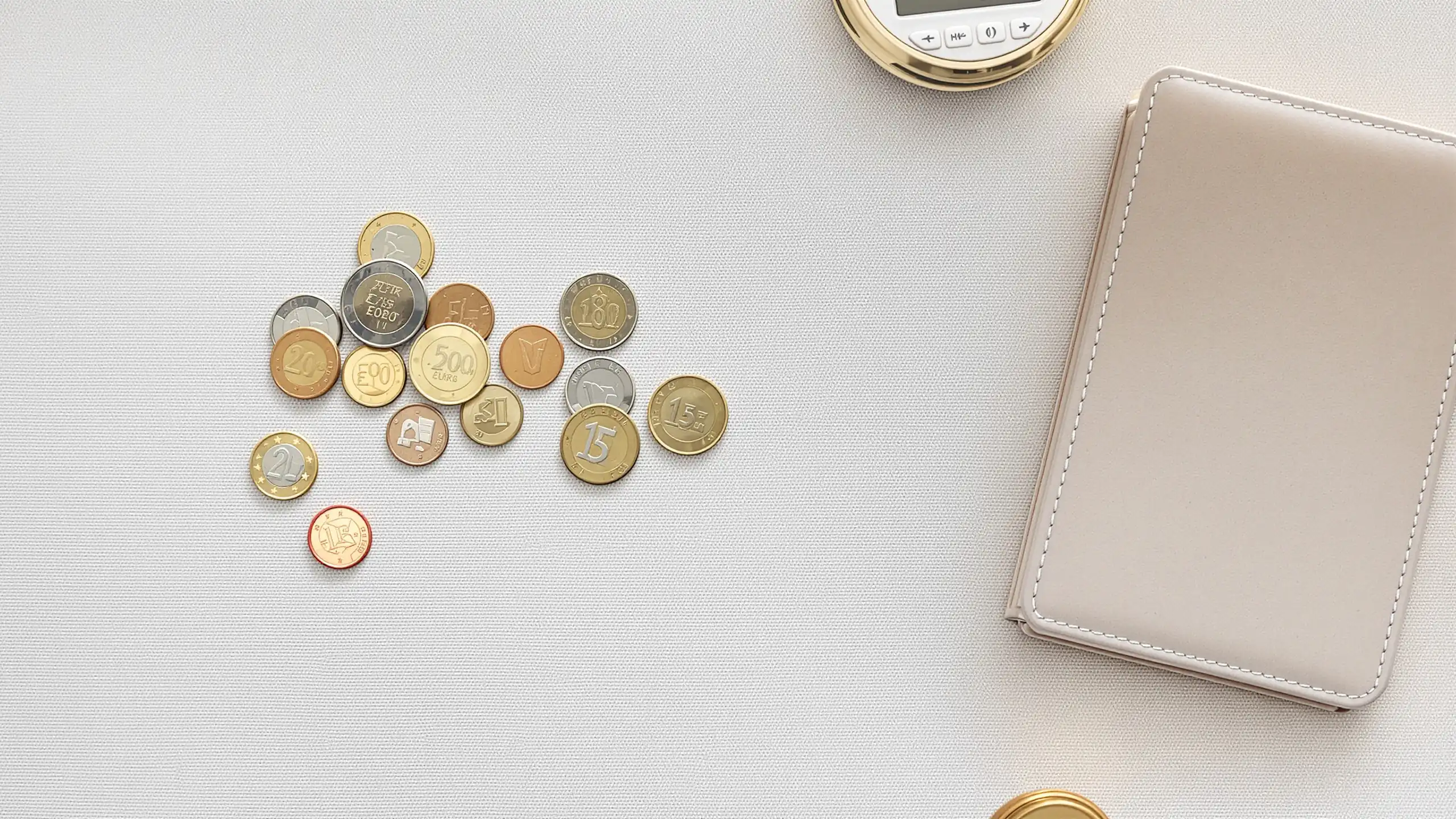 Euro-Münzen und ein Portemonnaie von oben auf hellem Tisch