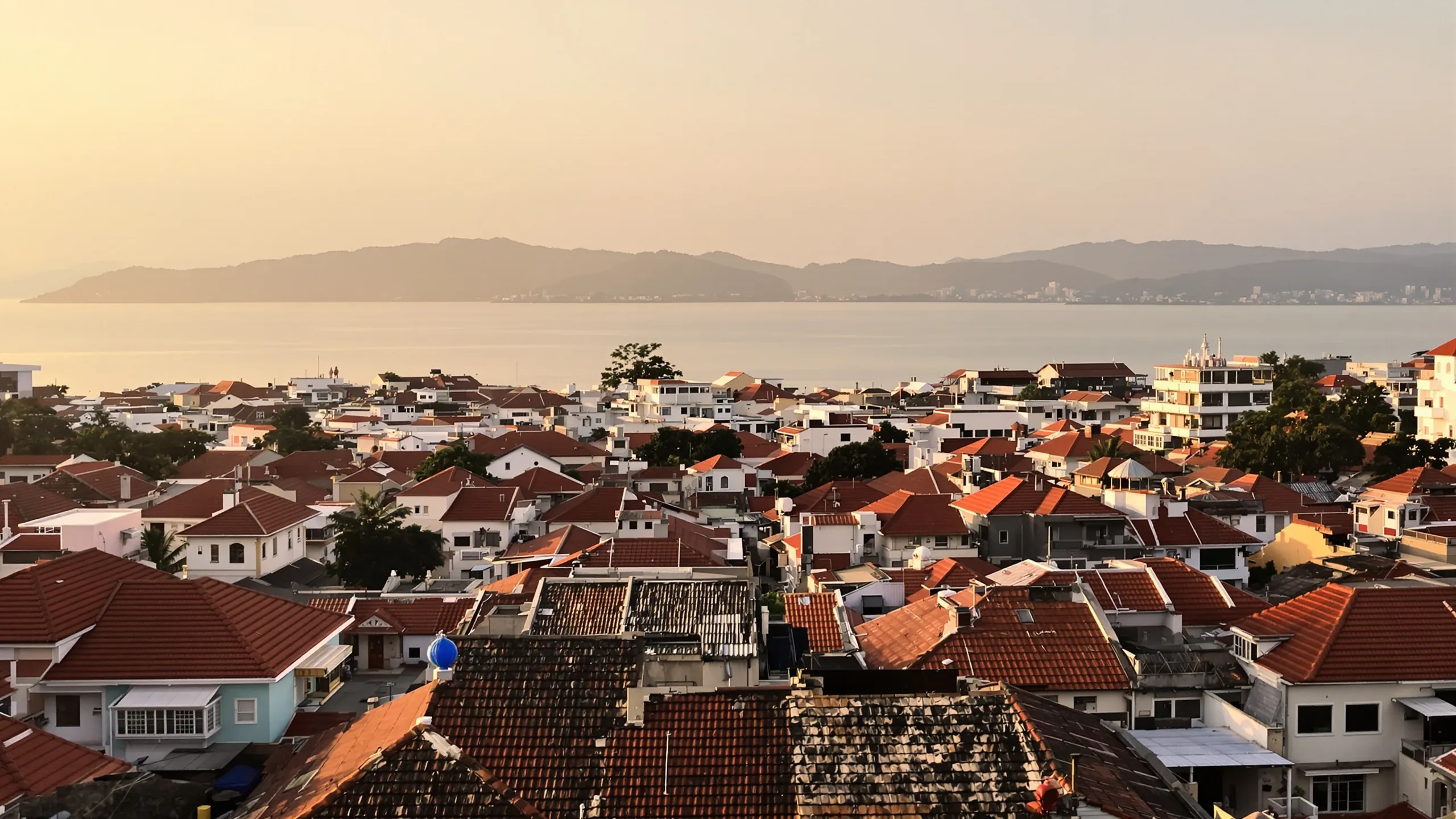 Küstenstadt mit roten Dächern am Meer im Morgenlicht